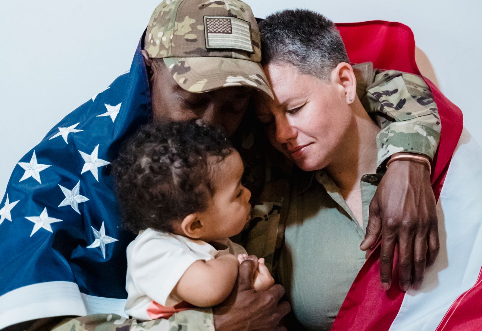 Military family holding their child with an American flag